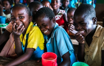 Junge Jungen teilen sich während des Unterrichts in Malawi einen Witz.