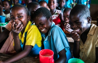 Junge Jungen teilen sich während des Unterrichts in Malawi einen Witz.