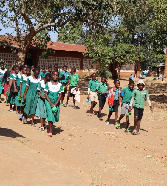 Children making their way to receive porridge